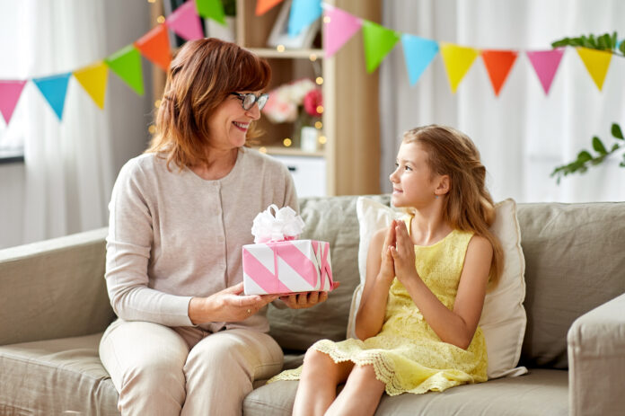 grandmother giving granddaughter birthday gift