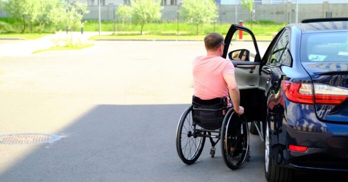 A,Man,In,A,Wheelchair,Closes,The,Door,Of,His A súlyos mozgáskorlátozott és egyéb fogyatékossággal élő személyek jogosultak a gépjárműadó-mentességre