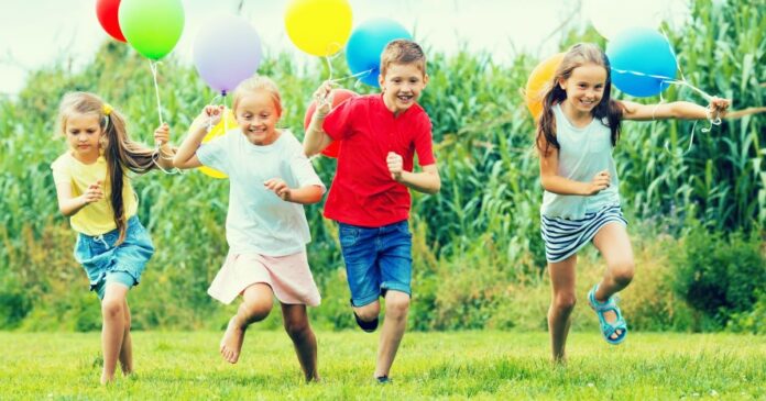 Playful,Boy,And,Girls,Running,And,Playing,With,Colorful,Balloons gyereknap
