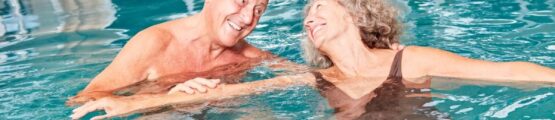 Vidám nyugdíjas pár a medencében.