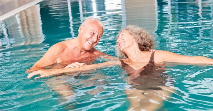 Vidám nyugdíjas pár a medencében.