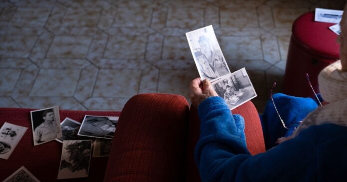 Unrecognizable,Widowed,Woman,Looks,At,Her,Husband's,Photos,During,Valentine's