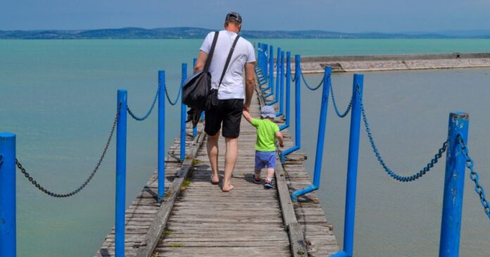 A,Man,And,A,Child,Walk,Along,A,Concrete,Pier Apa és fia a Balatonnál