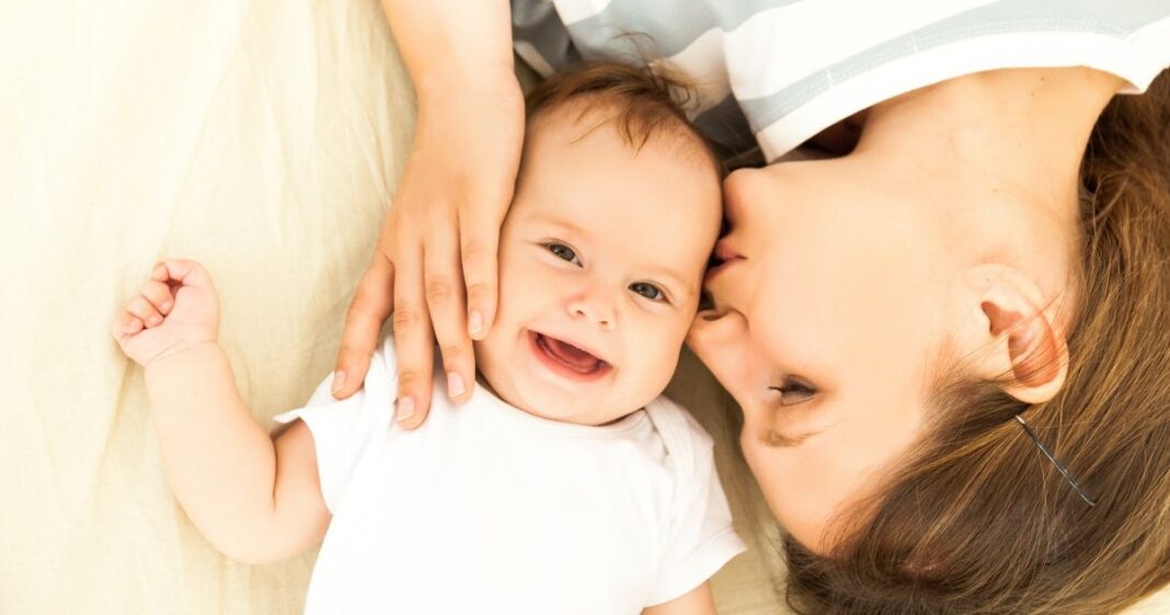 Boldog baba, akit éppen megpuszil az anyukája