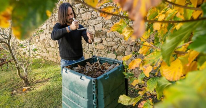 A,Man,Is,Mixing,The,Organic,Waste,With,Dry,Leaves Komposzt átforgatása
