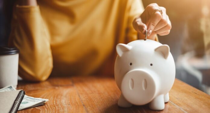 Woman,Hand,Putting,Money,Coin,Into,Piggy,For,Saving,Money