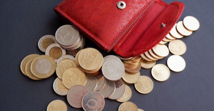 egy halom aprópénz kiöntve egy piros pénztárcából