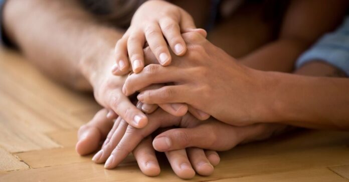 Close,Up,Of,Loving,Family,Stack,Hands,On,Warm,Floor