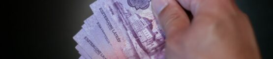 Sok tízezer forintos bankjegyet tart a kezében egy férfi.
