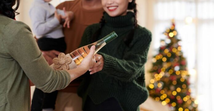 Hands,Of,Senior,Woman,Giving,Decorated,Bottle,Of,Champagne,Or Karácsonyi túlélési tippek házigazdáknak