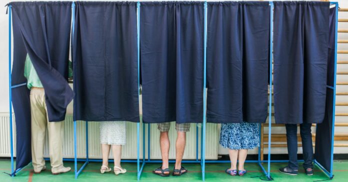People voting in booths választás 2024 átjelentkezés