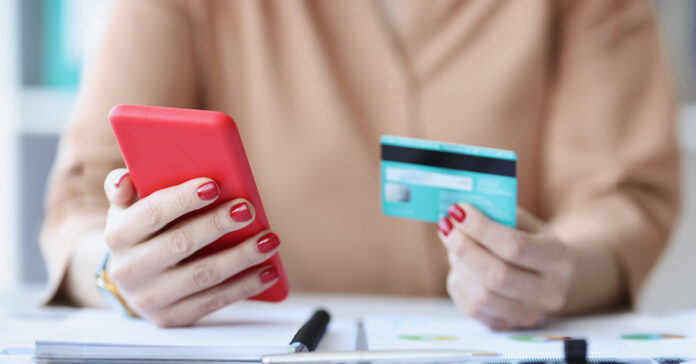 telefonon adja meg bankkártya adatait egy nő