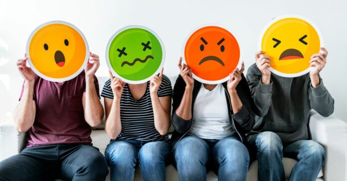 Emberek különböző emotikonokat tartanak az arcuk előtt