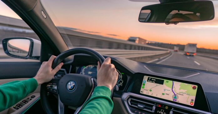 gyorshajtási bírság 2024 egy férfi zöld pulóverben BMW-t vezet napnyugta közben