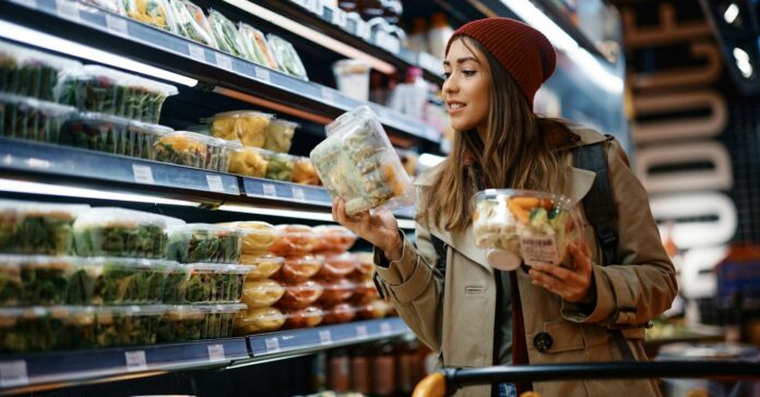 Fiatal lány előrecsomagolt saláták között válogat