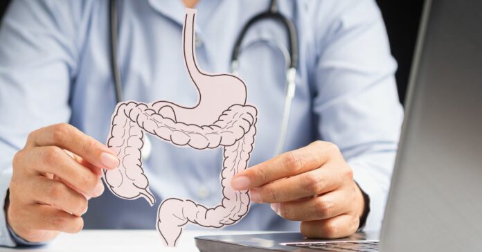 Rózsaszín, vastagbél alakú kartonlapot tart az orvos a kezében