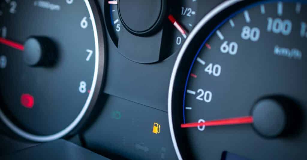 Alacsony üzemanyagszintre figyelmeztető jelzés egy autó műszerfalán