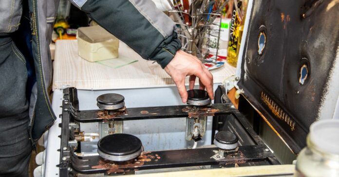 gázszerelő ellenőrzi a gáztűzhelyet