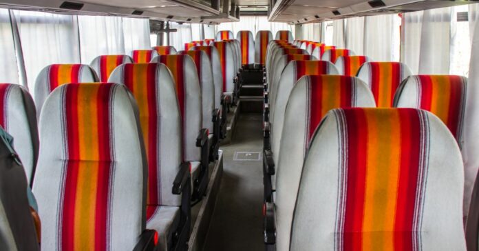 80-as évek magyar turistabusza, üres buszbelső, szürke-narancssárga ülések két sorban, középen folyosóval