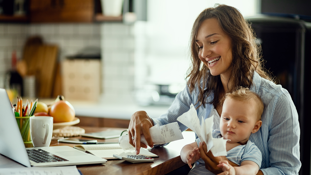 anyuka pénzügyeket intéz babával a kezében