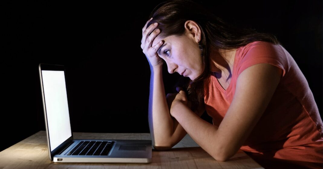 facebook-csalas-jelentese tehetetlen nő ül a laptop előtt