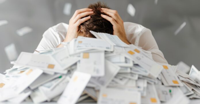 a férfit betemetik a számlák miközben fogja a fejét