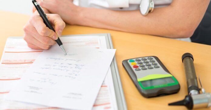 orvos az asztalon támaszkodik és igazolást ír