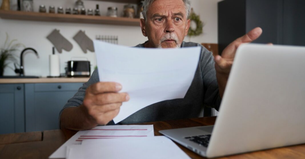csaló álláshirdetések nyugdíjas férfi banki papírral a kezében