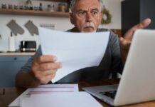 nyugdíjas férfi banki papírral a kezében