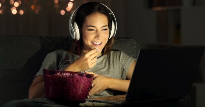 fiatal nő filmet néz a laptopján