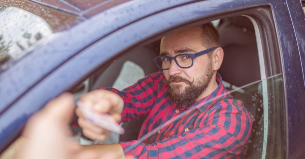 férfi igazoltatás során a hivatalos iratait nyújtja a rendőrnek