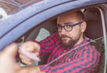 férfi igazoltatás során a hivatalos iratait nyújtja a rendőrnek