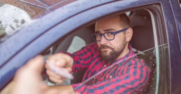 férfi igazoltatás során a hivatalos iratait nyújtja a rendőrnek