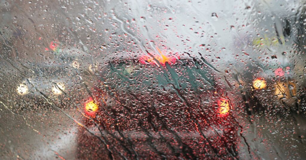 eső áztatta szélvédő, rossz látási viszonyok, egy piros autó halad előttünk