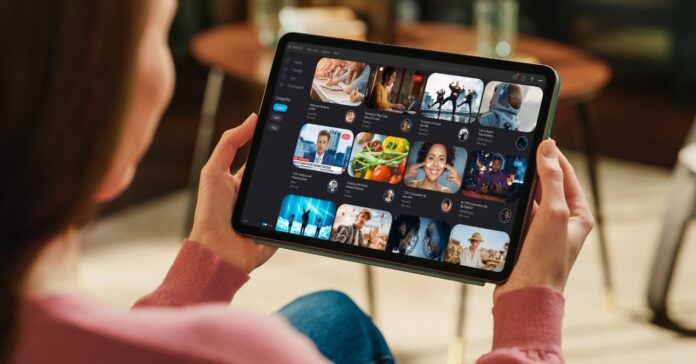 nő a kanapén ül otthonában és tableten internetezik