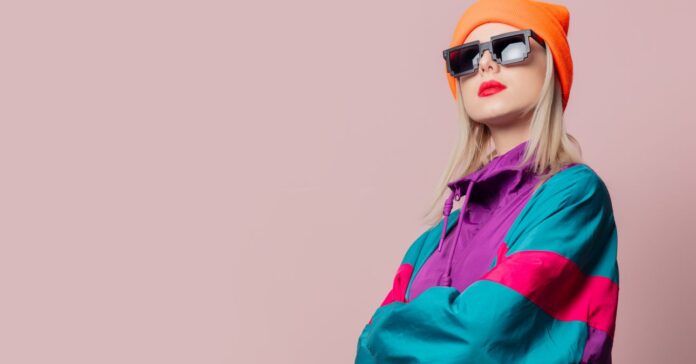 retró ruhadarabok csinos, fiatal nőn: színes melegítőfelső, nagy napszemüveg, sapka