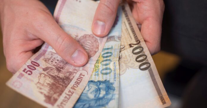 magyar bankjegyeket tart a kezében egy férfi