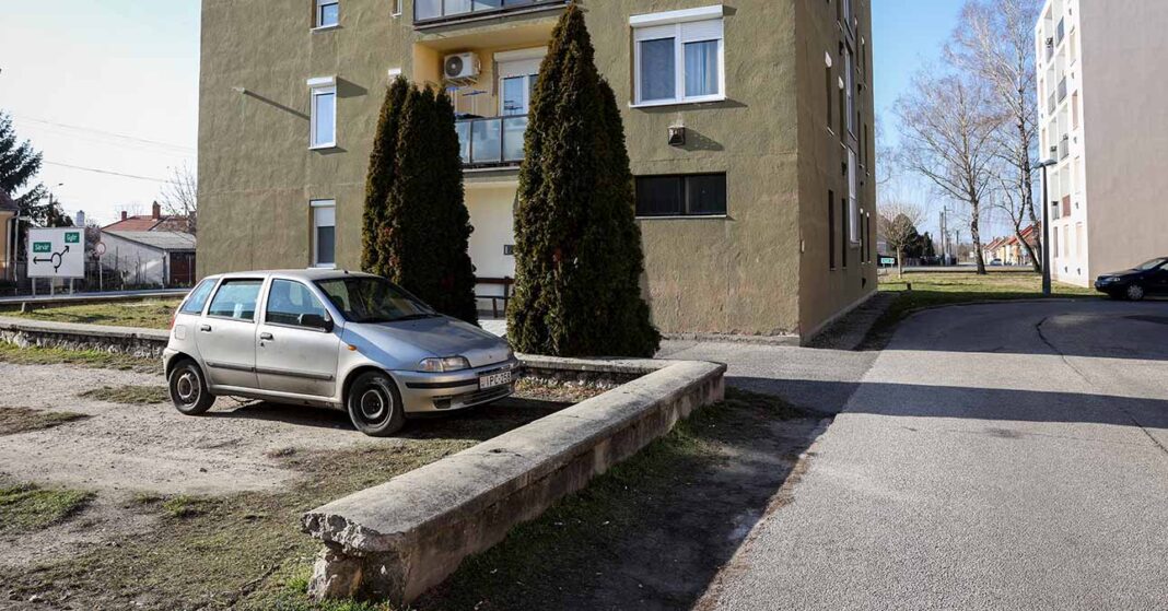kisvárosi társasház előtti parkoló egy autóval