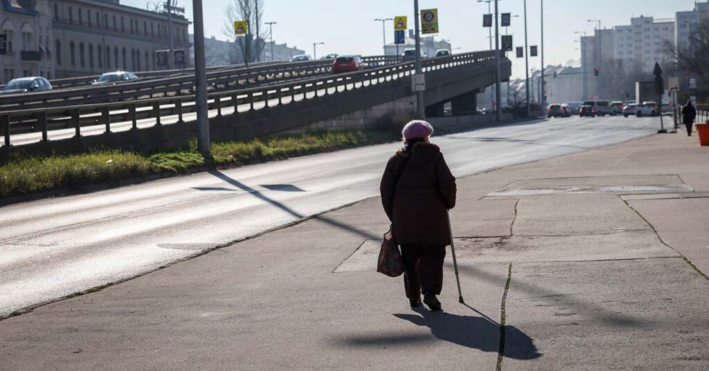 nyugdíjas magányosan sétál egy budapesti utcán