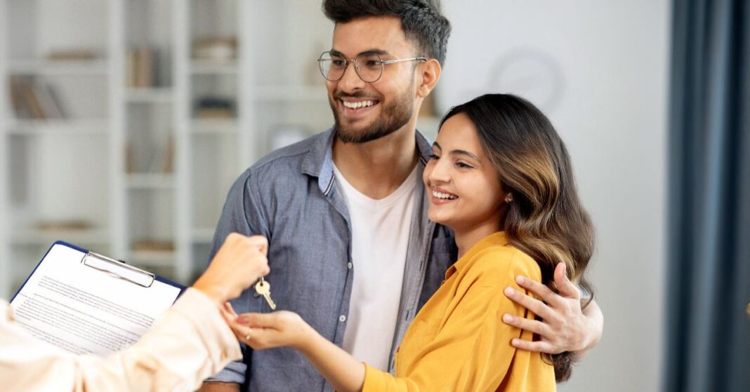 fiatal pár átveszi az új lakásuk kulcsát