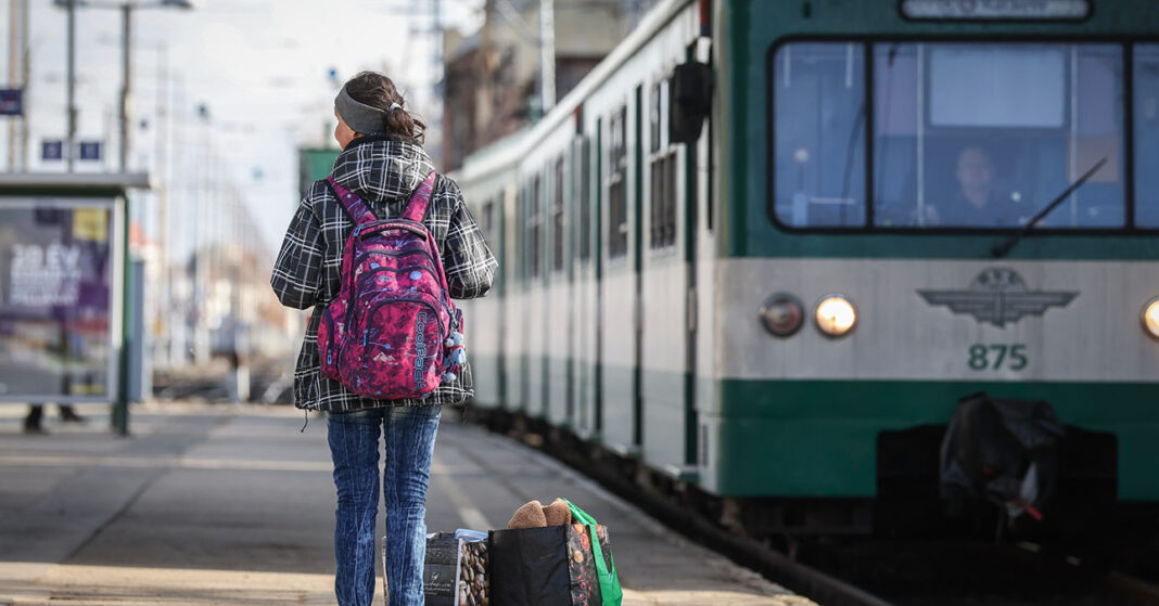 Egy kislány hátulról a hév mellett a peronon sétál