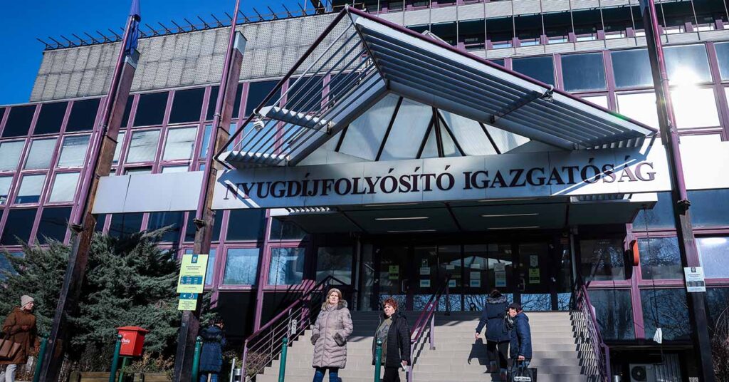 Nyugdíjas emberek beszélgetnek a Nyugdíjfolyósító épülete előtt Budapesten