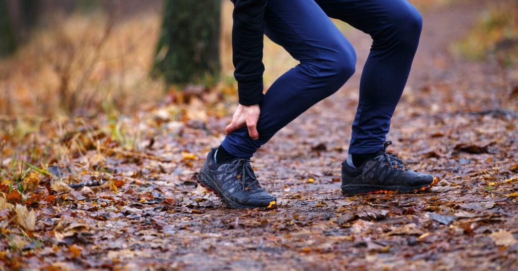 erdőben futó férfi a lábát fájlalja