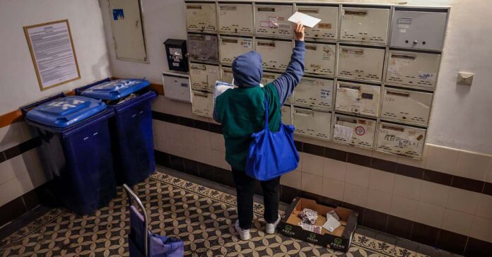 postás leveleket kézbesít egy társasházban