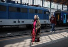 Melyikre jár kedvezmény a nyugdíjasoknak: bérletre, igazolványra vagy utalványra? Tisztázzuk az összes félreértést nyugdíjas néni fejkendőben, kabátban, bottal sétál a pályaudvaron