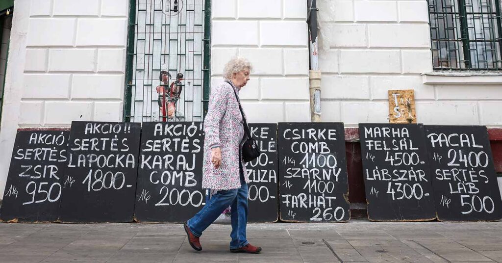 egy hentes előtt sétál el egy nyugdíj nő