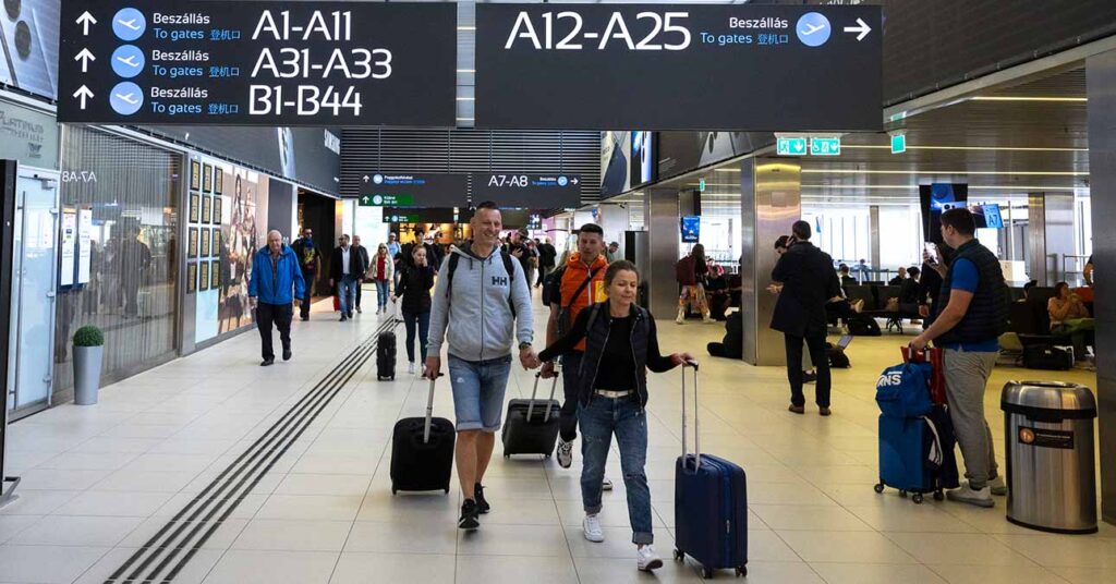 repülőtéren emberek bőröndökkel