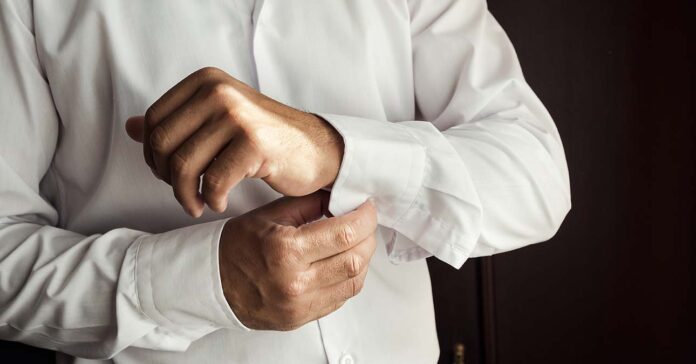 Férfi ing vasalás vasaló nélkül: a képen látható férfi már a mandzsettáit gombolja, az inge szép gyűrődésmentes