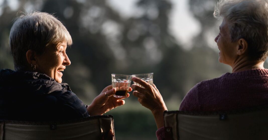 két idősebb nő kévával koccint