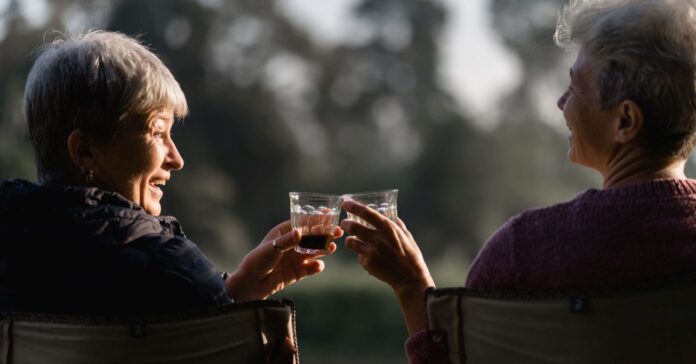 két idősebb nő kévával koccint